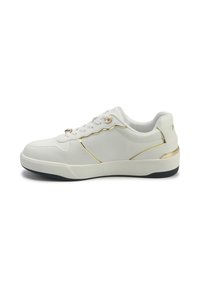 Valged sneakerid, mis on valmistatud siledast sünteetilisest materjalist, kuldsete aktsentide ja õmblustega. Omavad ümarat varvaste osa, nöörimise disaini ja musta kummist tallaga.