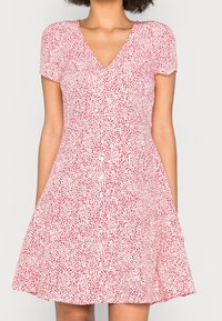 Rood en wit gestreepte jurk met korte mouwen, V-hals en knopen aan de voorkant; uitlopende rok; lichtgewicht stof.