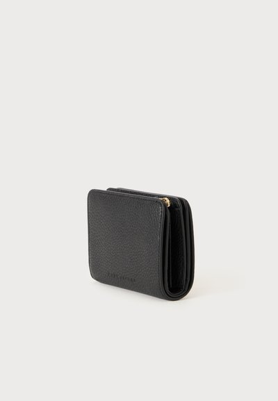 Portefeuille en cuir noir texturé avec un design plié et un détail visible de fermeture éclair dorée, photographié sur un fond clair.
