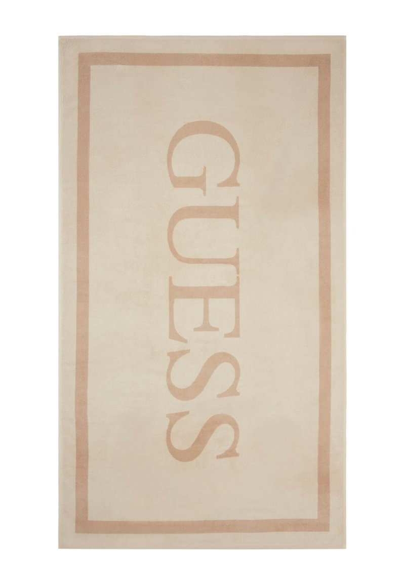 Tappeto color beige chiaro con un logo "GUESS" in un font beige scuro, bordato da una cornice rettangolare coordinata. Texture morbida.