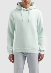 Vaaleanvihreä huppari kengurutaskulla, säädettävällä kiristysnauhalla, resorikahdenteilla ja helmalla. Rinnassa teksti "PURE PATH". Pehmeä kangaspinta.