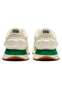 Tenisky Onitsuka Tiger s béžovým svrškem, černými akcenty a zelenou mezipodešví s texturovanou gumovou podešví.