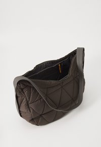 Brown quilted fabric shoulder bag with a textured surface, zip closure, and a wide strap. Spacious interior visible, featuring a colorful accent.