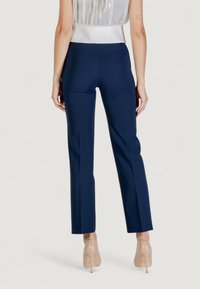 Pantaloni blu navy su misura con vestibilità slim, caratterizzati da una superficie liscia, dettagli di cuciture verticali e una discreta tasca posteriore.
