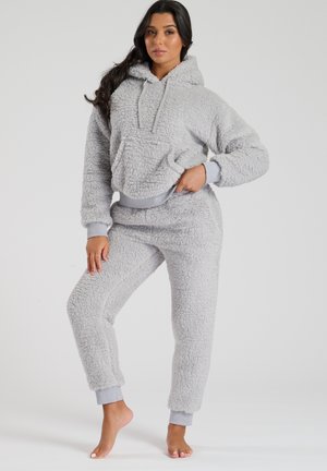 Set di abbigliamento loungewear grigio in felpa, composto da una felpa cropped con cappuccio e tasca a marsupio, e pantaloni abbinati con orli a costine.