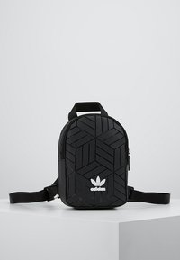 Svart ryggsäck med ett geometriskt texturerat mönster, utrustad med ett övre handtag, justerbar axelrem och en vit logotyp på framsidan.