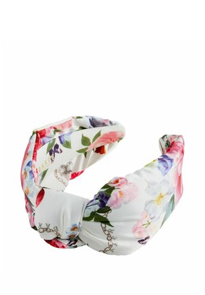 Weißes Stoffstirnband mit einem gedrehten Knoten, verziert mit bunten floralen Mustern in Pink-, Lila- und Grüntönen.