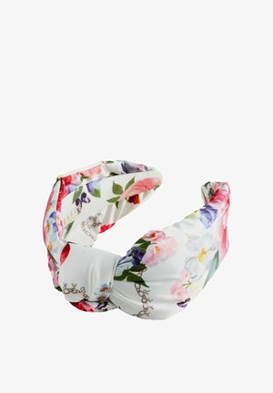 Weißes Stoffstirnband mit einem gedrehten Knoten, verziert mit bunten floralen Mustern in Pink-, Lila- und Grüntönen.