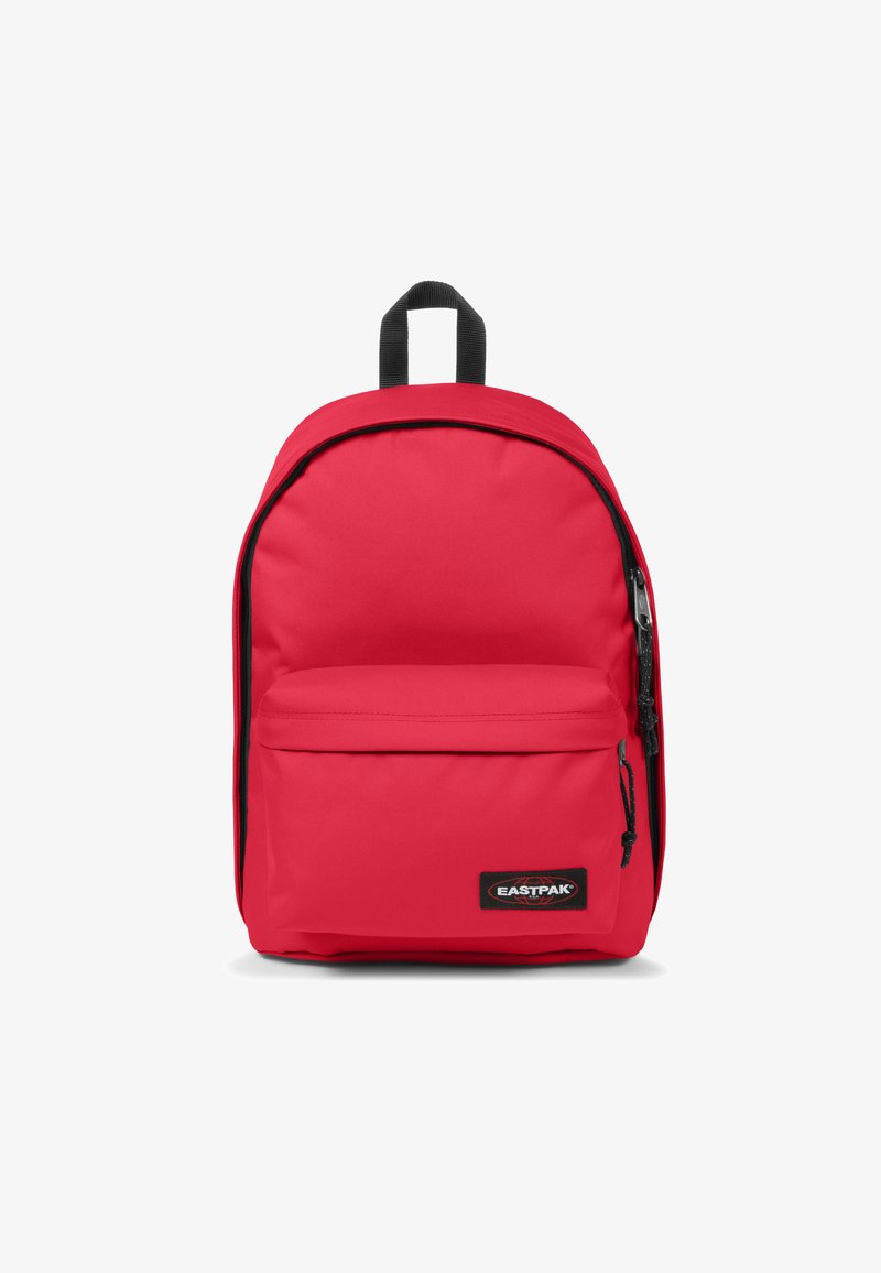 Mochila de tela roja con forma redondeada, bolsillo con cremallera en la parte frontal y acentos en negro. Cuenta con un asa en la parte superior y correas para los hombros para llevarla.