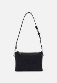 Black nylon crossbody bag with a zip closure, embossed "Karl" logo, adjustable strap, and silver-colored hardware accents.