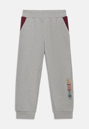Pantalon de survêtement gris clair avec taille et poignets côtelés, poches latérales bordeaux et logo coloré à motif en zigzag sur la partie inférieure de la jambe gauche.