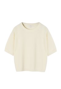 Pull en maille couleur crème à manches courtes, col rond, poignets et ourlet côtelés, présenté sur un fond blanc.