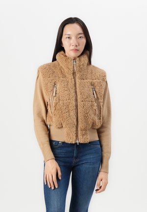 Giacca zip-up color sabbia con parte anteriore in shearling morbido, maniche a costine e due tasche con cerniera sul petto, dotata di un collo alto.