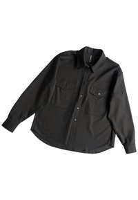 Black long-sleeve shirt featuring a button-down collar, two chest pockets, and a straight hem. Made of smooth fabric with a slightly structured fit.