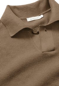 Braun gestreiftes Poloshirt mit Kragen, ausgestattet mit einem Knopf und einem Etikett. Strukturierter Stoff mit feinen vertikalen Linien.