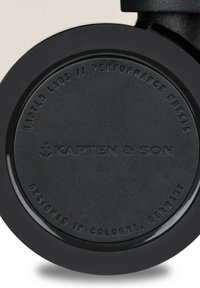 Schwarzes Sportlenkrad mit glatter Oberfläche, geprägtem Markennamen "KAPTEN & SON." Kreisförmiges Design, mit matter Oberfläche und ohne zusätzliche Akzente.