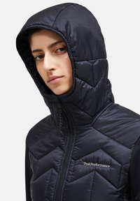 Black hooded puffer jacket with a quilted design, featuring a zipper and logo on the chest, made from shiny, lightweight material.