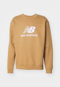 Smeđi dukserica s okruglim izrezom, s bijelim New Balance logotipom i tekstom smještenim u središtu. Izrađena od mekanog materijala, s rebrastim manžetama i donjim rubom.