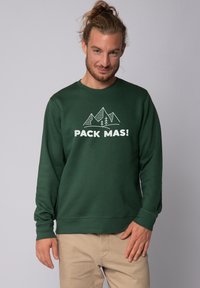 Sweatshirt vert à manches longues avec un graphique de montagne blanche et le texte "PACK MAS!". Tissu lisse et coupe décontractée.