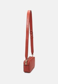 Borsa a tracolla rossa in pelle con finitura liscia, forma rettangolare, hardware dorato e tracolla regolabile. Chiusura con zip lungo il bordo superiore.