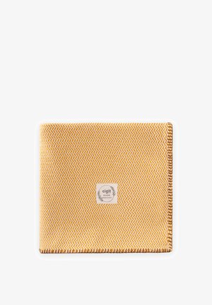 Żółto-biały tkanina o wzorze jodełki, z brązowymi obszytymi krawędziami i centralnie umieszczoną etykietą z napisem "cigit BOHEME premium quality".