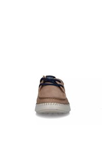 Zapato de cuero marrón claro con cordones azul marino, punta redonda y suela de goma blanca. Presenta costuras en contraste y un logo en la lengüeta.