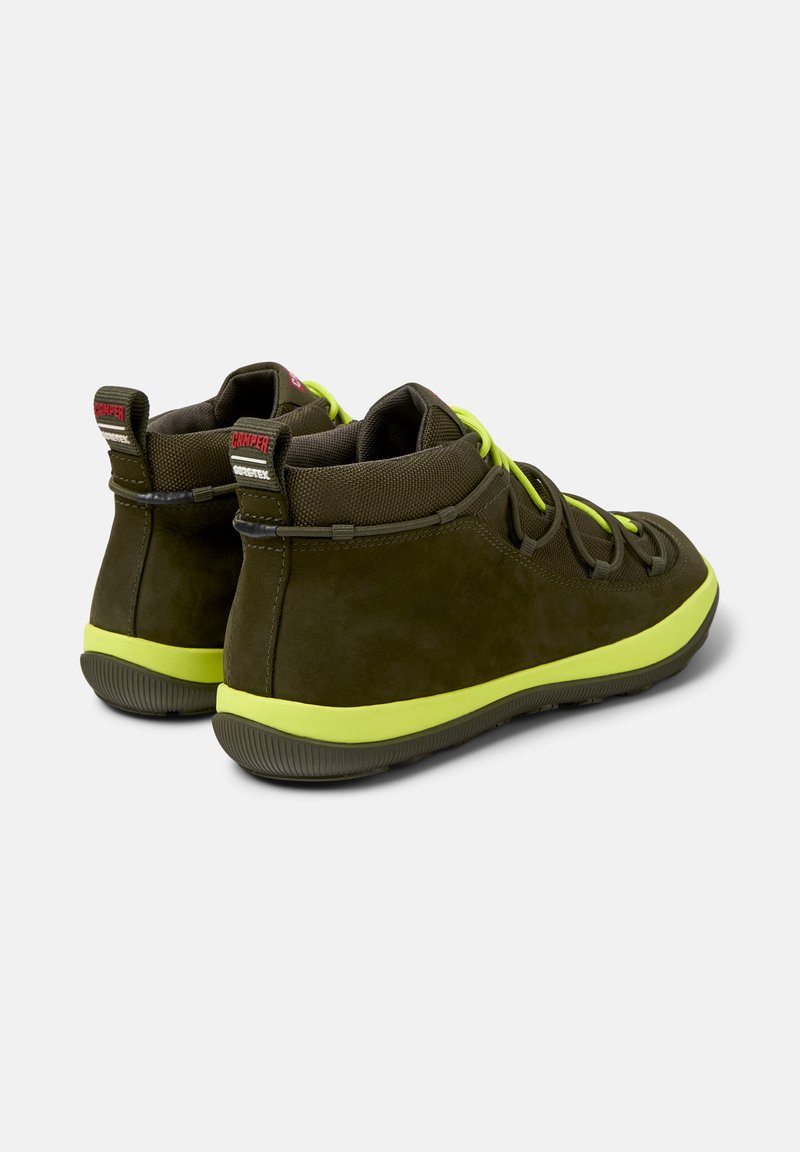 Bruine hoge schoenen met groene accenten en veters, die een gestroomlijnd ontwerp laten zien, geschikt voor casual kleding of buitenactiviteiten.