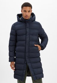 Granatowa puchowa kurtka z kapturem, z pionowymi przeszyciami, zapięciem na guziki i bocznymi kieszeniami. Gładka, lekka tekstura.