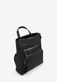 Mochila de tela negra con dos bolsillos con cremallera, detalles en cuero burdeos y un asa en la parte superior. Material texturizado y diseño estructurado.
