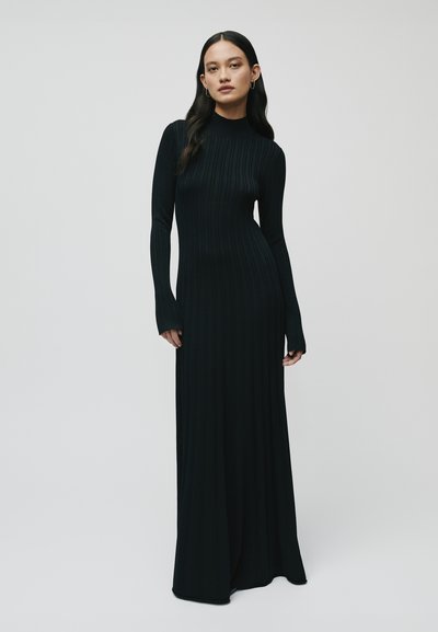 Abito maxi in maglia a coste nera con maniche lunghe e collo alto, che presenta un corpino aderente che si allarga all'orlo per un aspetto elegante.