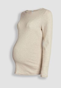 Beige zwangerschapstrui met lange mouwen en geribbelde structuur, aansluitend rond een zwangere torso, getoond op een paspop tegen een effen achtergrond.