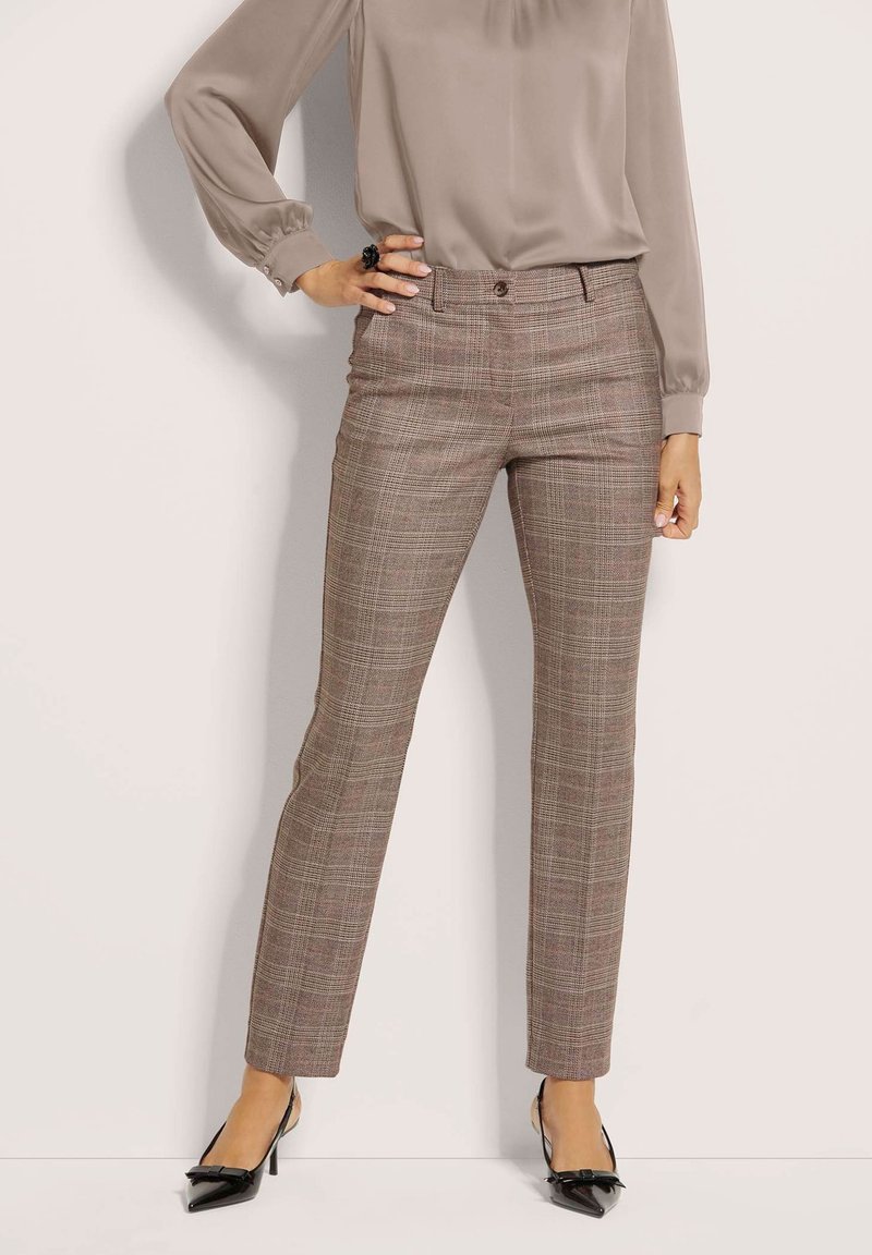 Karo-Hosen in Braun- und Beigetönen, mit slim fit, glatter Textur und vorderem Knopfverschluss, kombiniert mit einer neutralen Bluse.