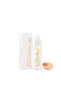 Szklana butelka z kulką, z złotą zakrętką, wypełniona małymi kawałkami kryształu. Biała pudełko z pomarańczowym logo i geometrycznym wzorem.