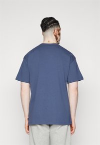 Mörkblå bomulls t-shirt med korta ärmar och rund halsringning, med en avslappnad passform och enkel baksidesdesign.