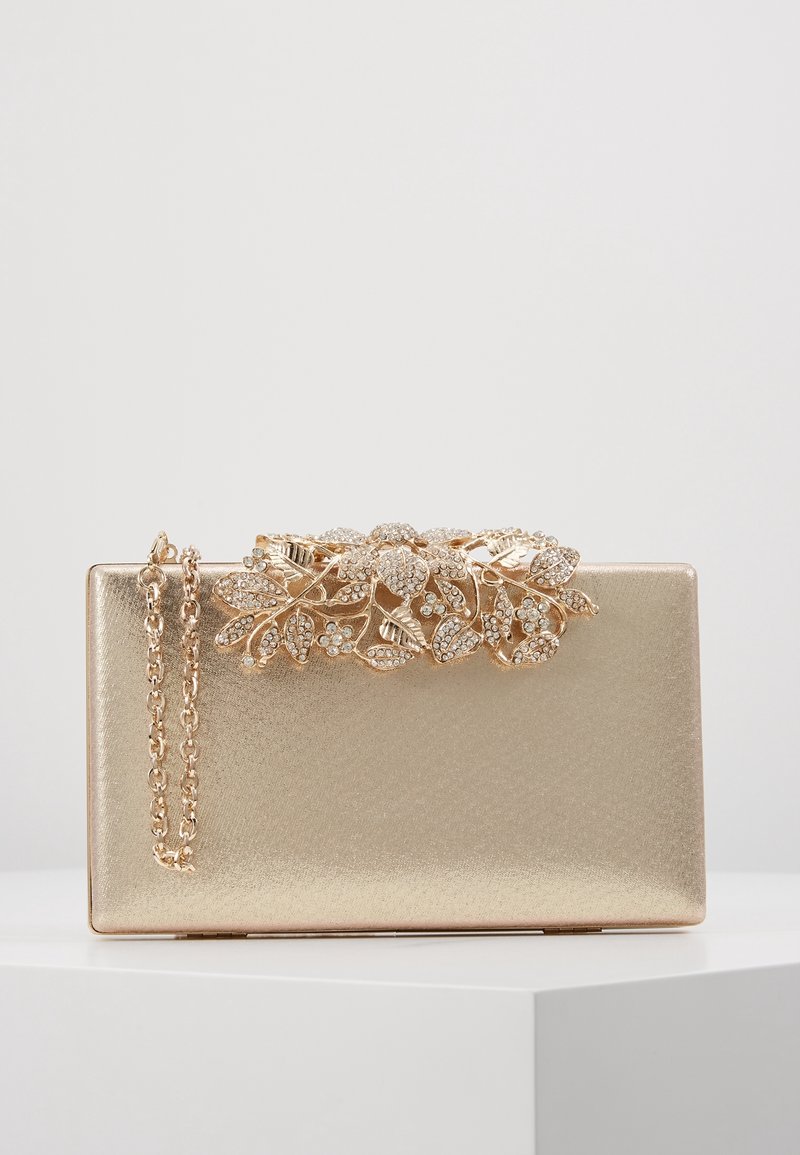 Pochette rectangulaire dorée avec ornements floraux en cristal sur le dessus et une anse chaîne dorée assortie.