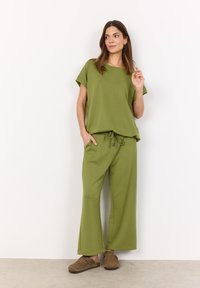 Green, loose-fitting t-shirt and matching wide-leg pants made of soft, textured fabric. Includes drawstring waist and side pockets.