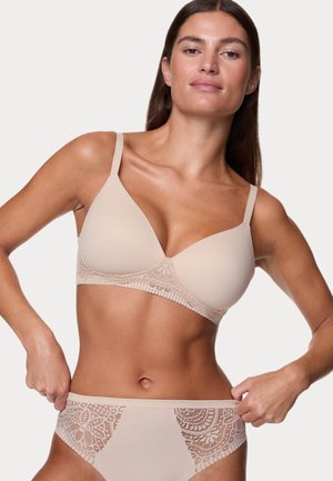 Ensemble de lingerie beige comprenant un soutien-gorge lisse avec un bord en dentelle et des culottes assorties avec des panneaux latéraux en dentelle, mettant en avant un design sans coutures.