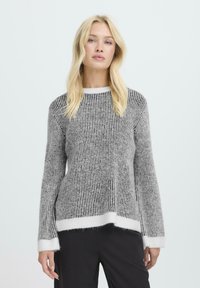 Hall šedate ja mustriliste triiksärkidega pehme tekstuuriga, millel on ümmargune kaelus ja valged soonikkudega mansetid ning ääred. Lahtine lõige ja minimaalne disain.