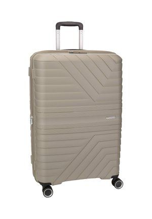 Hard shell suitcase in light beige, featuring diagonal grooves, a retractable handle, and four multi-directional wheels for easy transport.