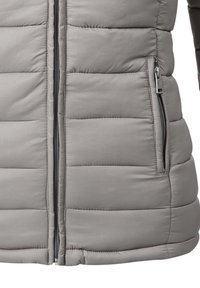 Giubbotto imbottito grigio con sezioni trapuntate, zip frontale completa e tasche laterali con zip. Tessuto liscio e leggero con una finitura opaca.