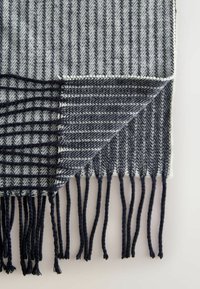 Gewebte Decke mit Fischgrätmuster in Grau und Marineblau, mit fransigen Kanten und unterschiedlichen Texturen auf jeder Seite.