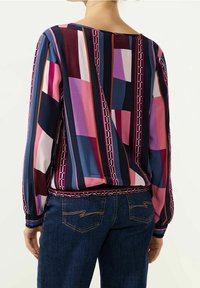 Long-sleeve top in multicolored geometric patterns with shades of pink, purple, and navy. Features elasticated waistband and cuffs.