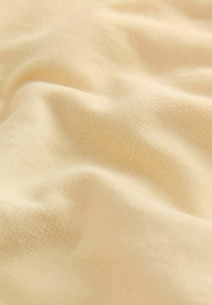 Ljusgult tyg med en mjuk, texturerad yta som har fina, jämna vävningar, vilket skapar mjuka veck och subtila skuggor.