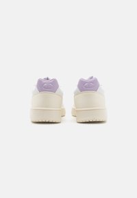 Sneaker bianche con accenti lavanda, realizzate in pelle e materiali sintetici, dotate di collare imbottito e suola texturizzata.