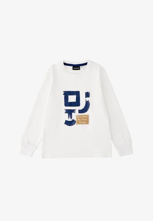 Camicia bianca a maniche lunghe con simboli astratti blu e una toppa beige con la scritta "Remember My Asian Voyage" sul davanti.