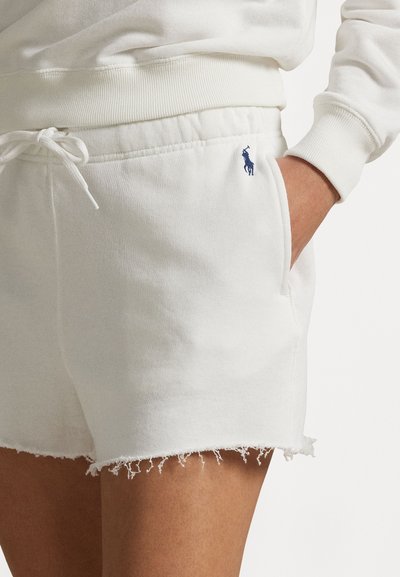 Weiße Baumwollshorts mit fransigem Saum, seitlichen Taschen und blauer Logo auf der Vorderseite. Elastischer Bund mit verstellbarem Kordelzug.