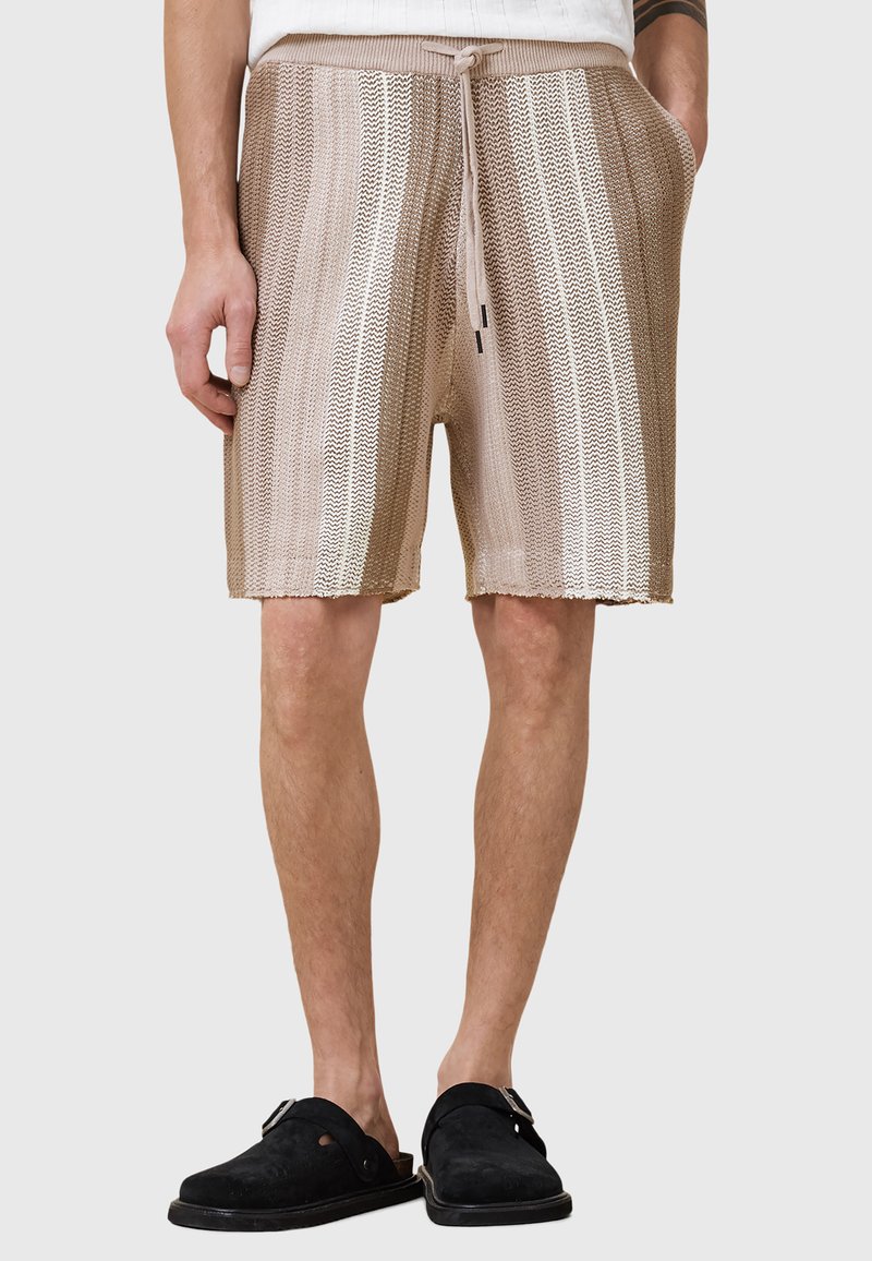 Beige gestrickte Shorts mit hellen und dunklen horizontalen Streifen, elastischem Bund, Kordelzug und Seitentaschen. Kürzer als knielang.