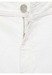 Valkoiset farkut lähikuvassa, joissa on hopeinen nappi ja vetoketju, yksinkertainen muotoilu, sileä pinta ilman näkyviä kuvioita tai koristeita.