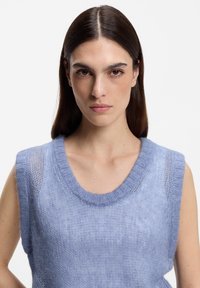 Hellblaues ärmelloses Stricktop mit rundem Ausschnitt, ausgestattet mit einem feinen, strukturierten Muster und gerippten Kanten.