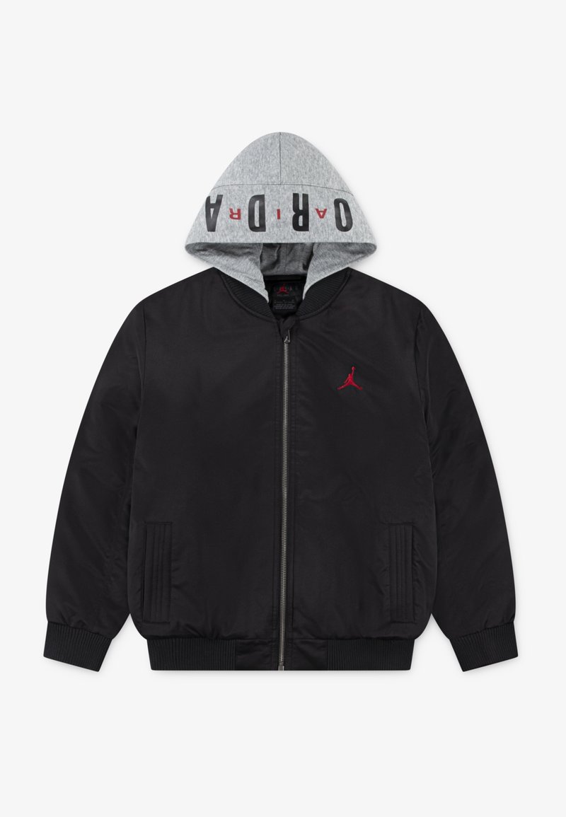 Veste noire zippée avec poignets et ourlet côtelés, capuche grise avec texte "JORDAN", et petit logo Jumpman rouge sur la poitrine.
